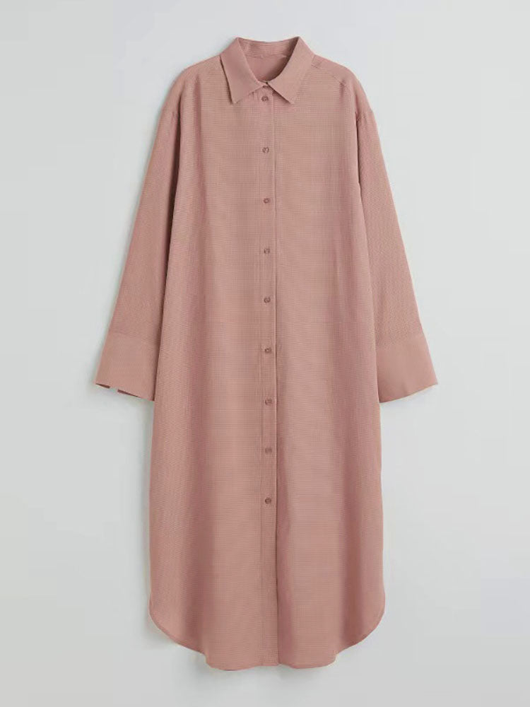 A long pink collared shirt dress laid flat, showing button-down front and textured fabric.