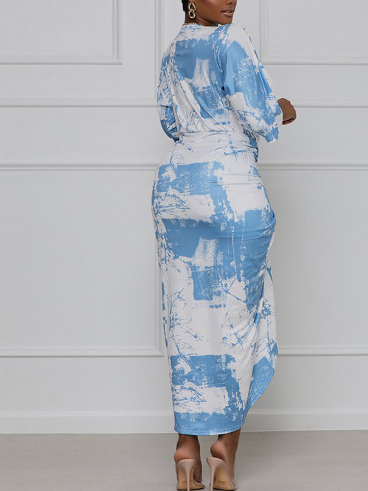 Back view of a woman in a blue and white tie-dye print wrap dress.