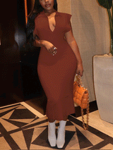 Woman in a brown ribbed knit midi dress with cap sleeves and a collared V-neck, styled with white ankle boots and an orange handbag.