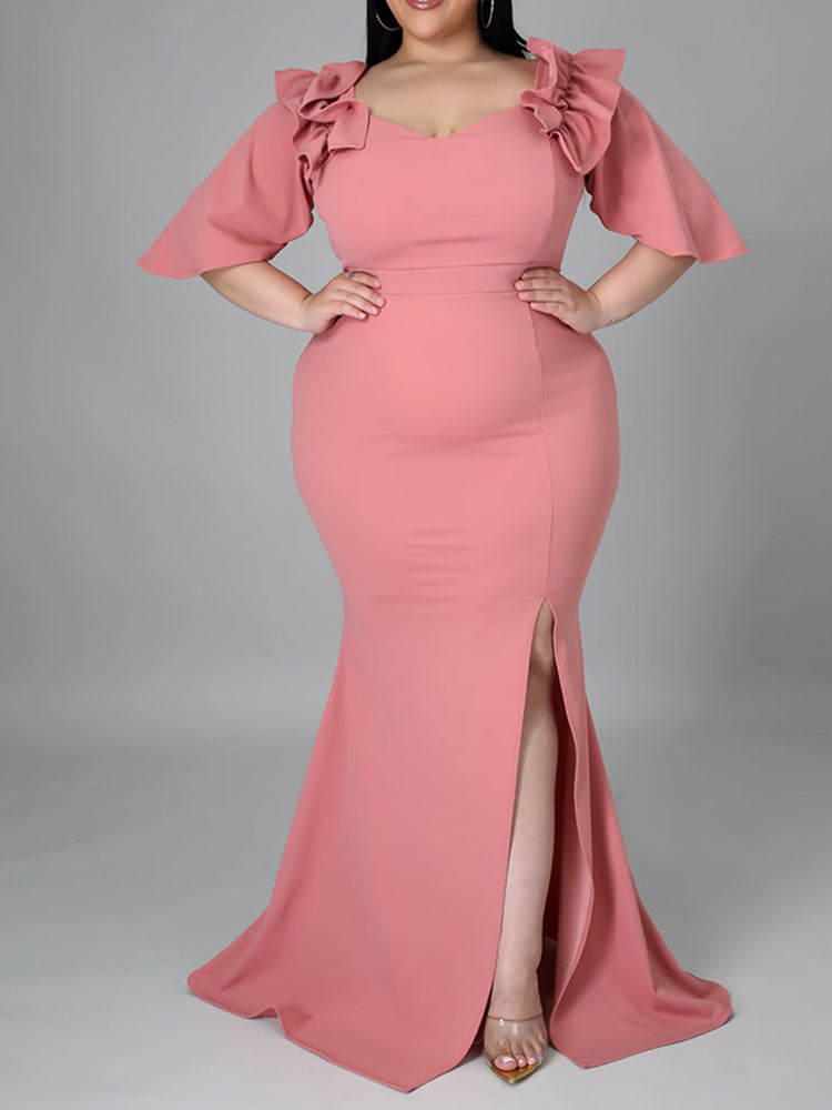 Full body shot of a woman in a pink formal dress with flutter sleeves