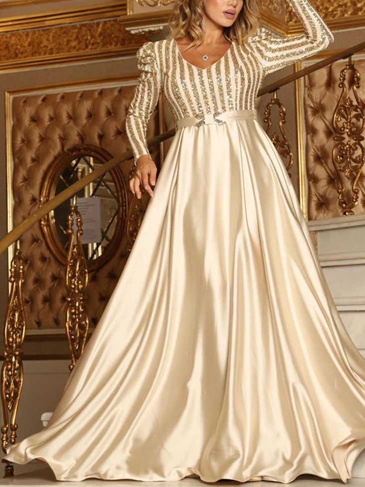 Woman wearing a champagne long-sleeved A-line formal dress with a sequined striped bodice and a satin skirt.