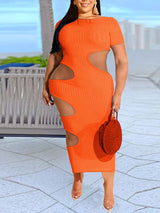 Woman wearing an orange midi dress with cut-out details on the sides and a ribbed texture.