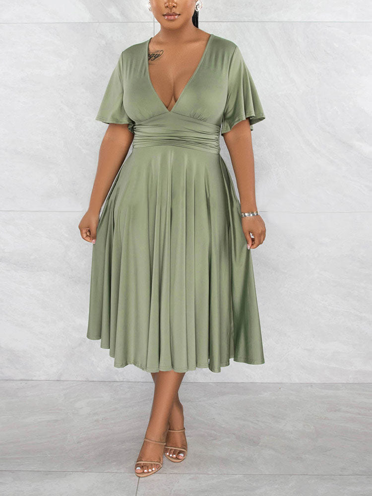 Woman wearing a light green midi dress with a V-neck and flutter sleeves