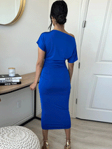 back view of a woman in a royal blue one-shoulder ruched midi dress