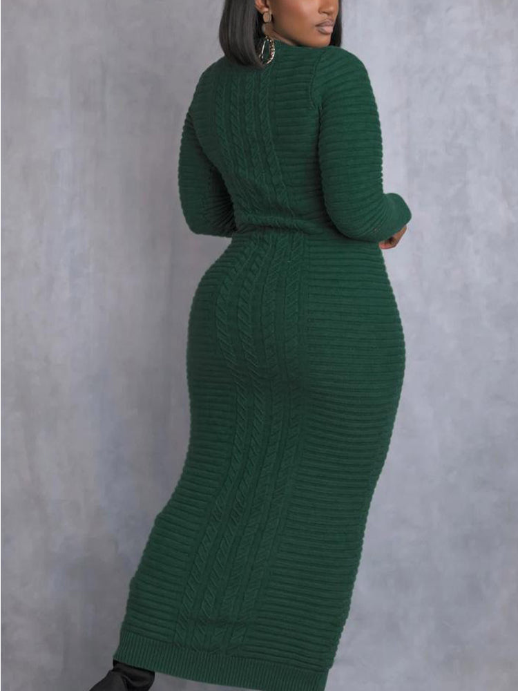 Back view of a woman wearing a long green cable knit dress with long sleeves and a mock neck.