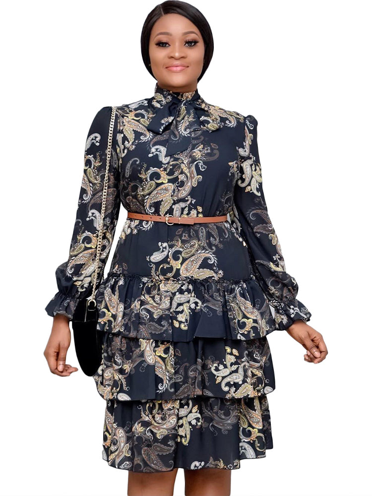 woman wearing a black tiered dress with a paisley print, brown belt, and black purse