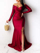 Woman wearing a red off-the-shoulder long-sleeved mermaid gown with a high slit