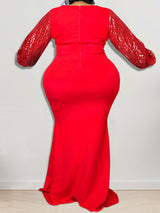Rear view of a woman in a red mermaid dress with sequined sleeves and a zippered back.