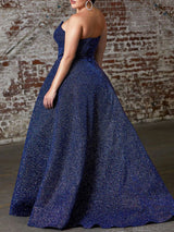 Back view of a navy blue sparkly strapless ball gown with a full skirt.