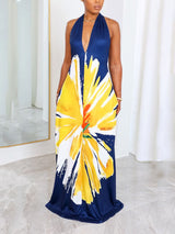 Front view of a woman in a floral print maxi dress with a halter neckline and deep v-neck.