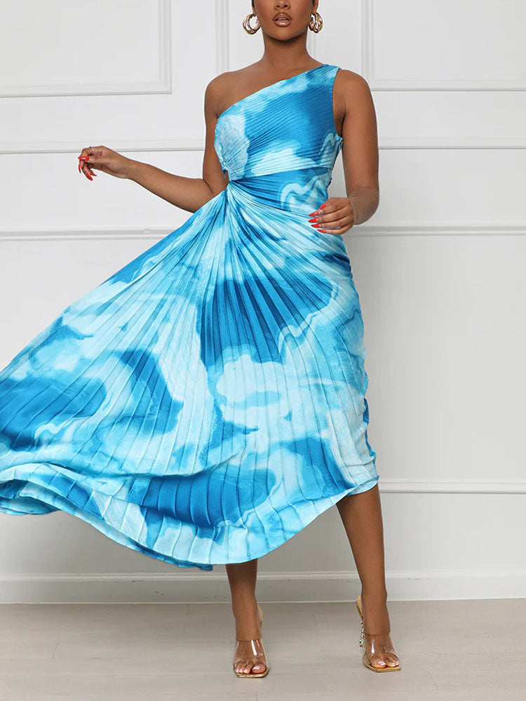 Woman wearing a blue tie-dye one-shoulder pleated maxi dress, with fabric flowing.