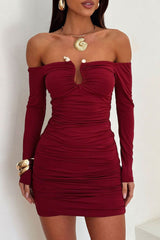 Close-up of a model wearing a deep red off-the-shoulder ruched bodycon dress with long sleeves and a keyhole cutout, showcasing the neckline detail.