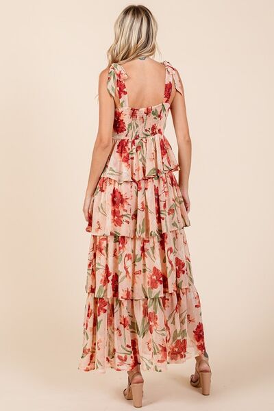 Back view of a woman wearing a blush pink floral print tiered maxi dress