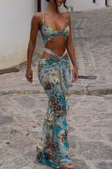 Woman wearing a two-piece resort wear set with a printed crop top and a matching wrap maxi skirt, walking on a cobblestone path.
