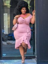 Woman wearing a pink off-the-shoulder ruched bodice dress with ruffle trim and a fit-and-flare skirt.