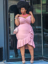 Close-up of a woman in a pink off-the-shoulder dress, showcasing the ruched bodice and ruffle trim.