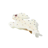 Close-up of white resin bunny hair clip with rhinestones and gold accents