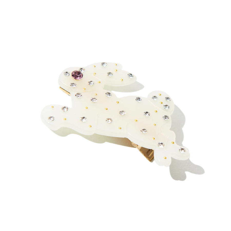 Close-up of white resin bunny hair clip with rhinestones and gold accents