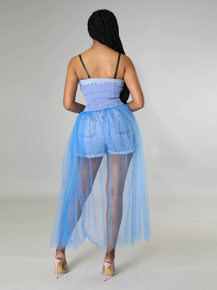 Woman wearing a light blue denim corset top with a long, sheer light blue tulle skirt over denim shorts, back view.