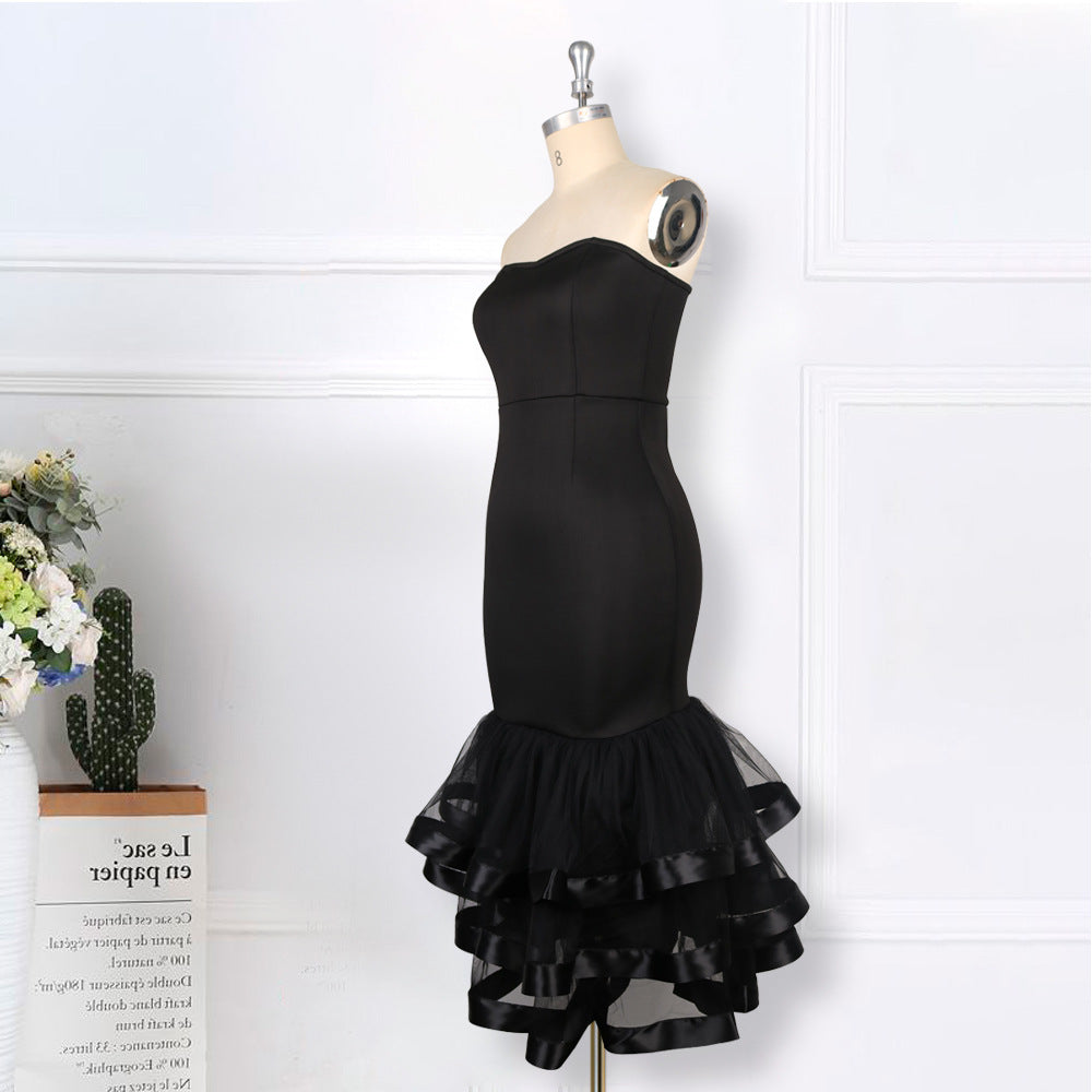 Black strapless mermaid dress with a tiered ruffled skirt and ribbon accents displayed on a mannequin.