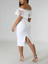 Woman in a white off-the-shoulder midi dress, back view showing slit hem.
