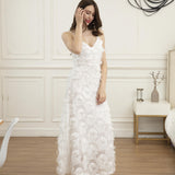 Woman wearing a white feather-trimmed midi dress with spaghetti straps and a v-neck, posing indoors.