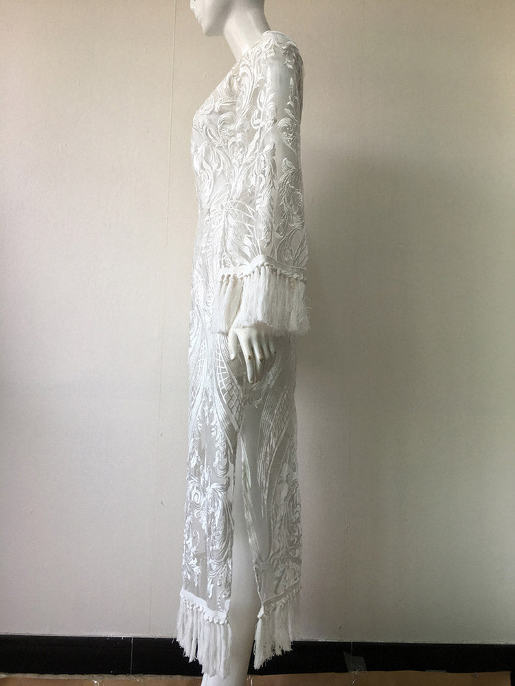 side view of a white lace dress on a mannequin, showcasing the long bell sleeves with fringe and the midi length with a slit and fringe hem