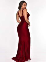 Woman wearing a floor-length, dark red satin mermaid dress with a sweetheart neckline and a high slit, posed from the back.