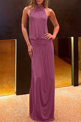 woman wearing a plum halter neck maxi dress with ruched empire waist