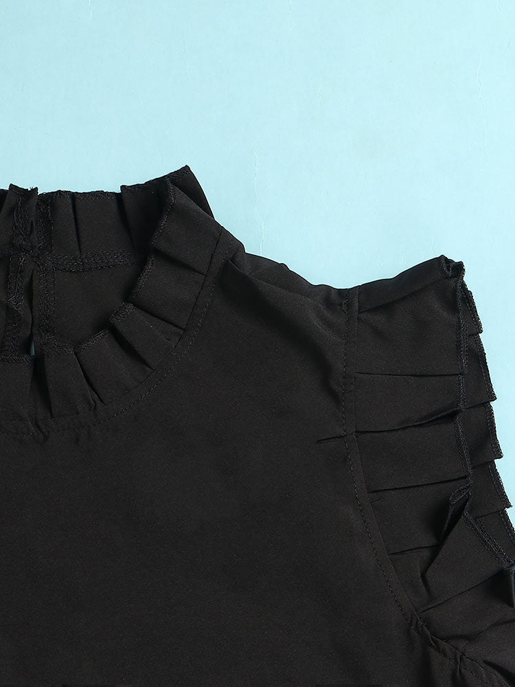 Close-up of the ruffled neckline and sleeves of a black dress