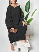 Woman posing in a black off-the-shoulder maxi dress with batwing sleeves