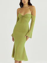 Woman wearing a lime green ruched halter neck dress with sheer off-the-shoulder sleeves and a flared hem.