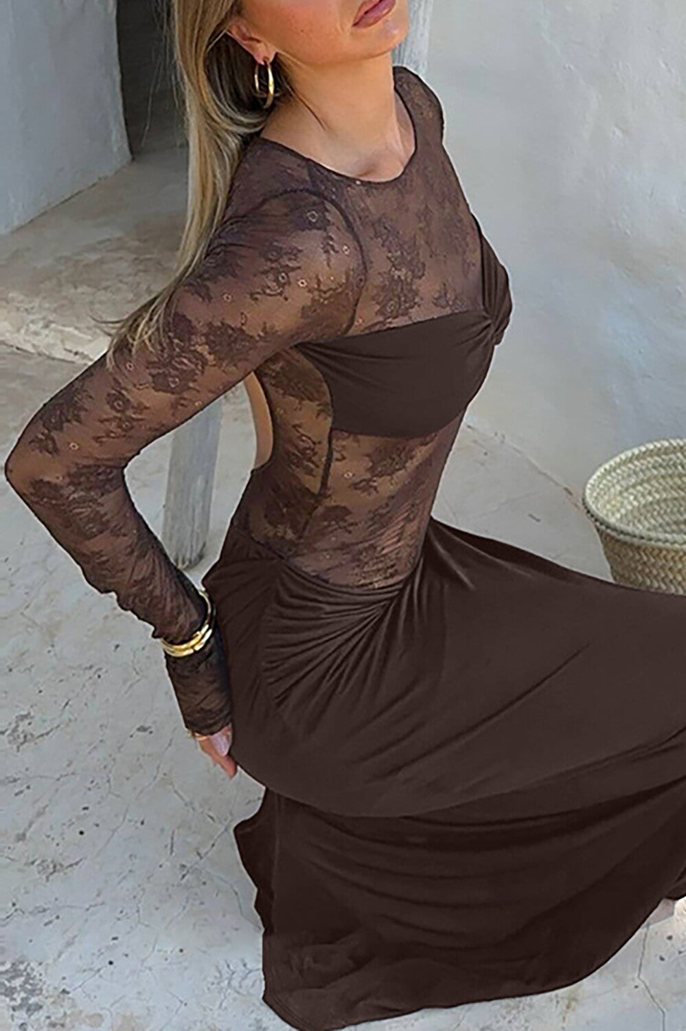 Woman in a long brown lace dress kneeling, showing the back detail.