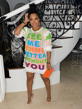 Woman posing in a white sequined t-shirt dress with colorful text.