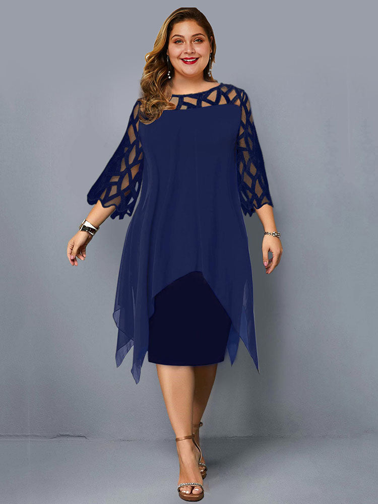 Plus-size woman wearing a navy blue layered dress with geometric mesh sleeves and an asymmetrical hemline, standing against a grey background.
