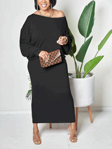 Woman wearing a black off-the-shoulder maxi dress with batwing sleeves
