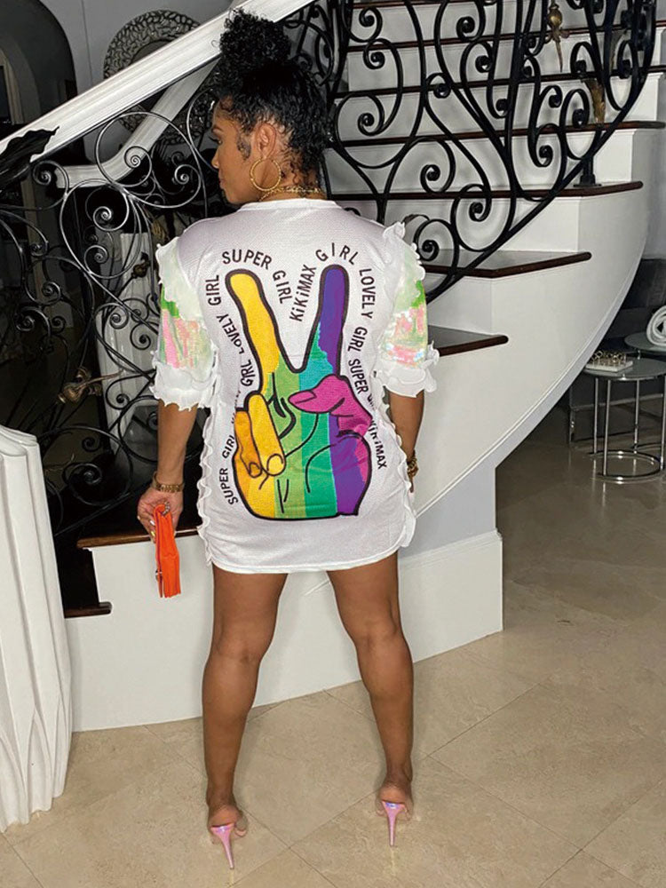 Woman from behind in a white sequined t-shirt dress with a rainbow peace sign.