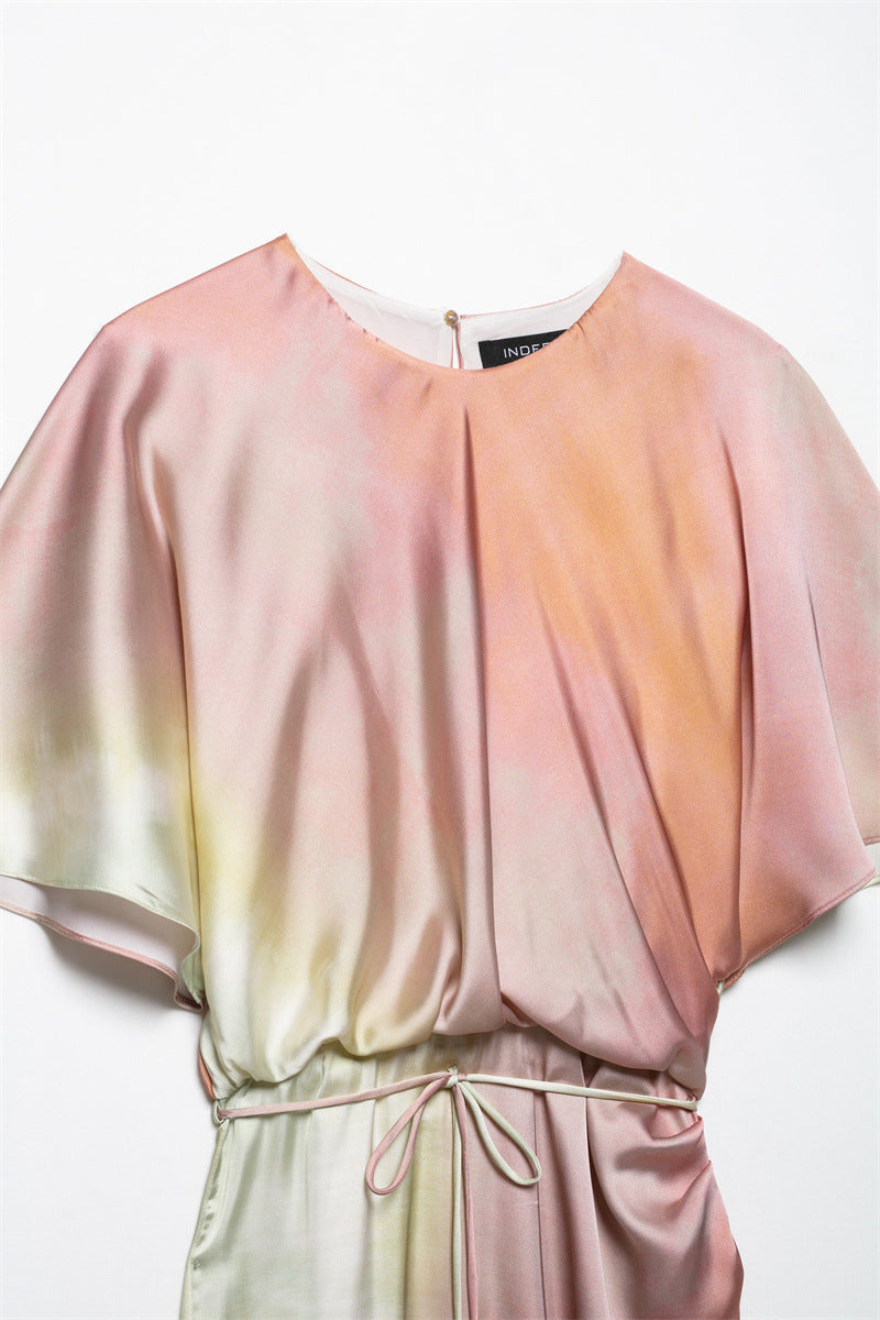 close-up of the round neckline and draped bodice of a pink, yellow, and orange ombre satin midi dress with batwing sleeves