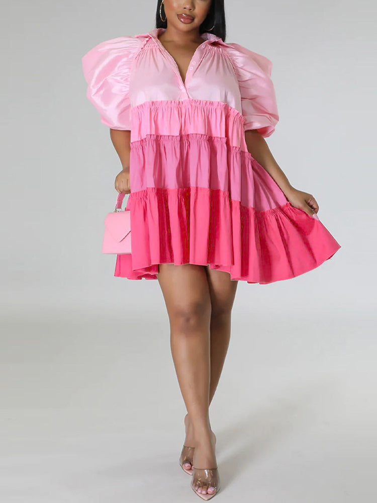 Woman posing in a pink tiered mini dress with puff sleeves, showing the dress movement