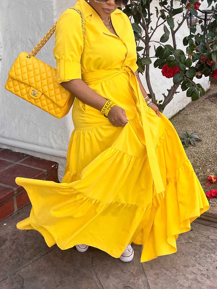 Woman twirling in a yellow tiered maxi dress, showing the movement of the skirt.