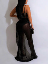 Rear view of a woman in a black sequined maxi dress with a sheer overlay.