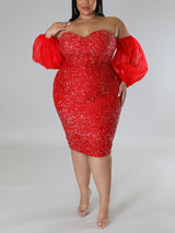 A plus-size model in a red sequined off-the-shoulder dress with puff sleeves, touching her shoulder.