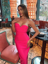 Woman in a bright pink strapless midi dress posing in a restaurant
