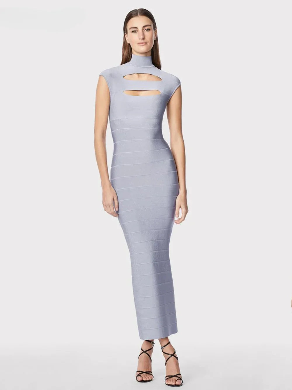 Model wearing a light blue sleeveless bodycon maxi dress with cut-out detail at the bust and high neckline, standing against a white background.