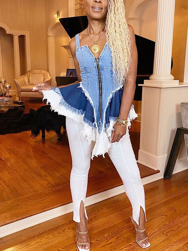 Woman in a denim top with a zippered front and ruffled hem, paired with white pants.