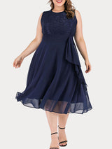 Woman in a navy blue A-line dress with lace bodice and chiffon skirt, showcasing the ruffle detail