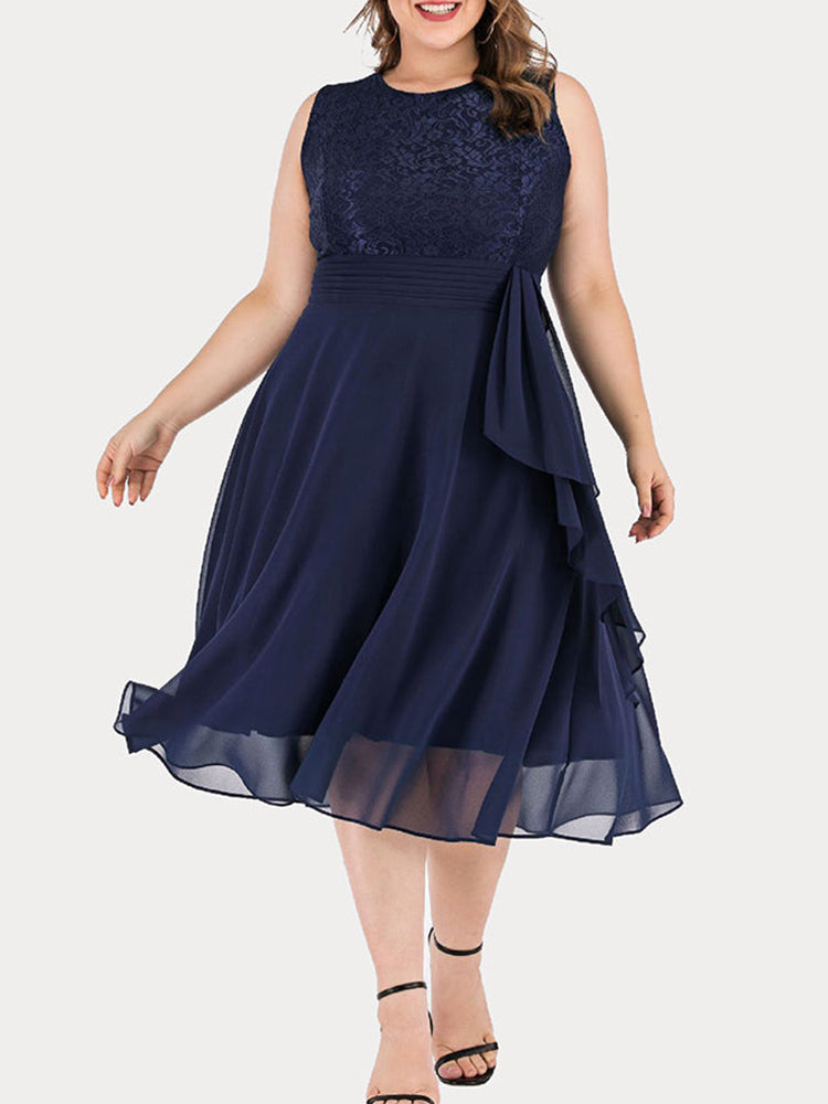 Woman in a navy blue A-line dress with lace bodice and chiffon skirt, showcasing the ruffle detail