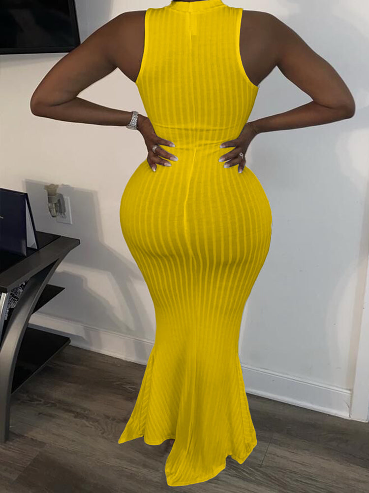 Back view of a woman wearing a yellow sleeveless ribbed knit maxi dress with a mermaid hem and mock neckline.