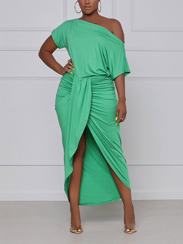 woman wearing a green one-shoulder draped dress with a high slit