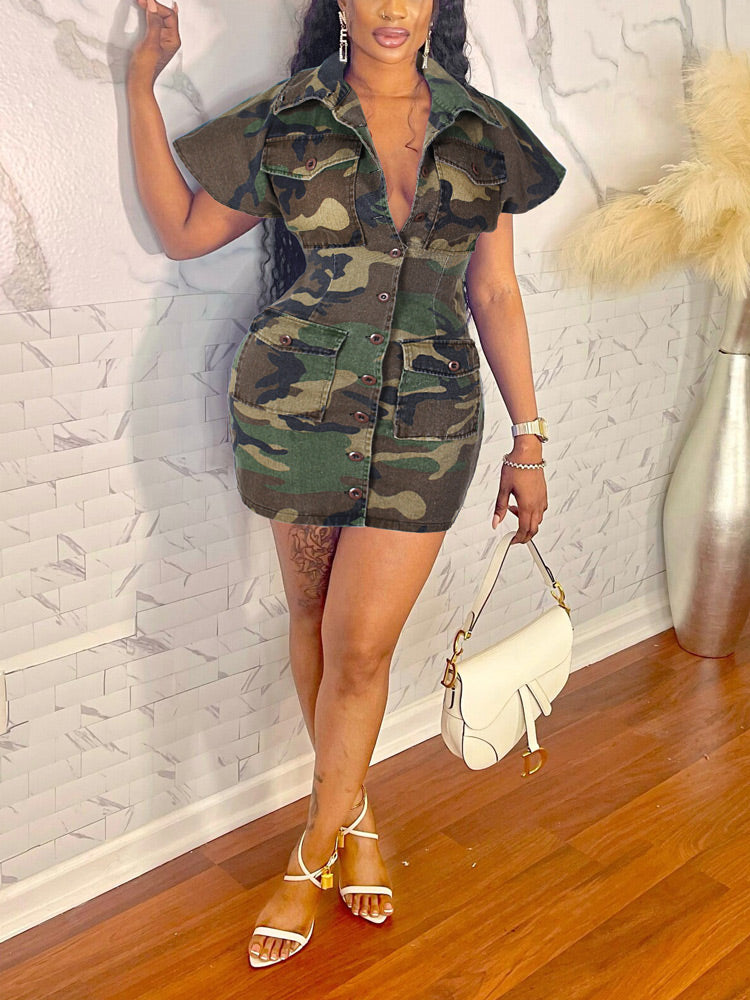 Woman wearing a camouflage print short sleeve button-down dress with four front pockets and white heeled sandals.